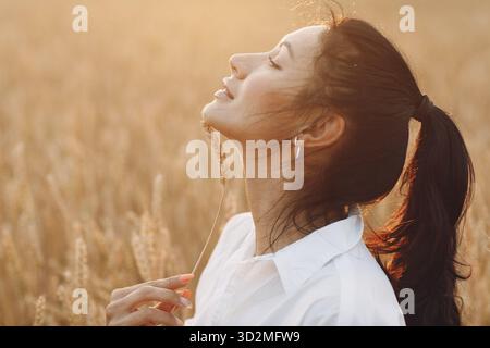 Portrait d'une belle femme brunette avec des oreilles de blé sur son visage Banque D'Images