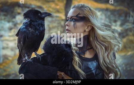 Belle corbeau noir, femme blonde viking avec bouclier et épée, tresses dans ses cheveux Banque D'Images
