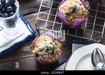 Muffins aux myrtilles frais servis sur la table en bois de la cuisine rustique Banque D'Images