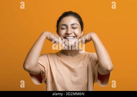 Gros plan portrait d'une jeune femme indienne américaine faisant du facebuilding yoga visage gymnastique yoga automassage Banque D'Images