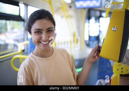 Femme indienne payant sans concession avec une carte pour les transports en commun bus ou tram Banque D'Images