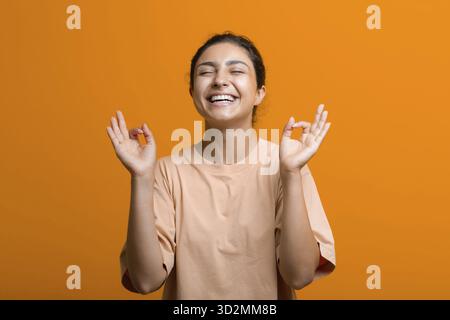 Portrait de jeune adulte femme indienne réussie méditant zen comme avec OK signe mudra geste Banque D'Images