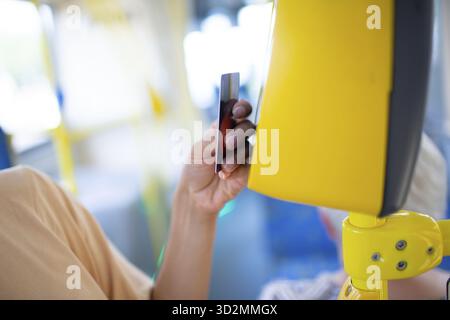 Femme payant sans concession avec une carte pour les transports en commun bus ou tram Banque D'Images