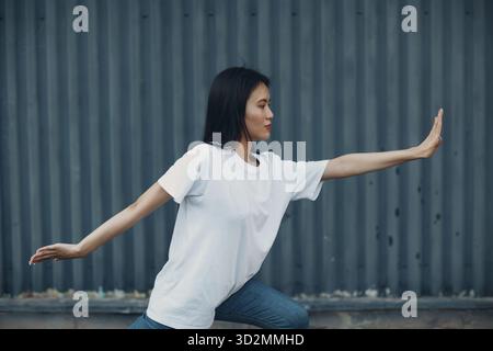 Jeune femme asiatique faisant de l'exercice qigong été à l'extérieur Banque D'Images