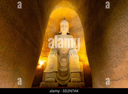Plan vertical d'une statue géante de Bouddha dans une grotte située dans la province chinoise du Sichuan. Banque D'Images