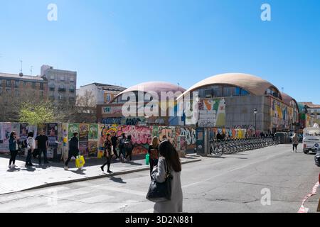 Des piétons passant devant le marché alimentaire historique de Mercado de la Cebada, couvert d'une art de rue graffiti colorée dans le quartier de La Latina à Madrid Banque D'Images