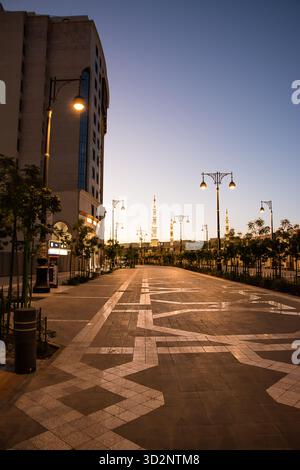 Medina, Arabie Saoudite - 21 avril 2025 : avenue Medina au coucher du soleil avec minaret illuminé en arrière-plan Banque D'Images