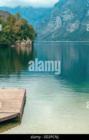 Jetée en bois rustique sur le rivage du lac Bohinj, Slovénie, paysage pittoresque du lac alpin avec une eau turquoise calme et les montagnes environnantes. foc sélectif Banque D'Images