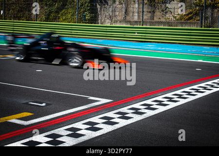 Mouvement Bliurred du panneau de ligne d'arrivée de franchissement de voiture noire sur la piste asphaltée Banque D'Images