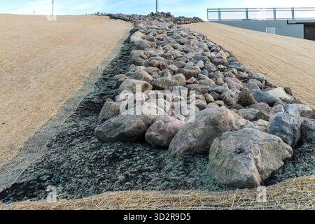 Contrôle de l'érosion des pentes en bordure de route avec une couverture de filet unique installée sur le sol pour protéger contre les mauvaises herbes et l'érosion par l'eau Banque D'Images