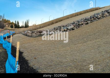 Contrôle de l'érosion des pentes en bordure de route avec une couverture de filet unique installée sur le sol pour protéger contre les mauvaises herbes et l'érosion par l'eau Banque D'Images