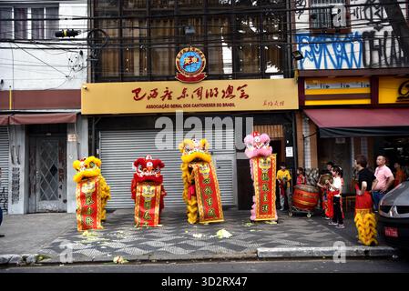 Tan Xunyi (première à droite), un compatriote chinois étranger travaillant dans le commerce extérieur, transformé en professeur de batterie pour enseigner les techniques de batterie à de jeunes membres de l'équipe à São Paulo, Brésil, le 25 octobre 2025. São Paulo, Brésil.26 octobre 2025. L'événement annuel double neuvième Festival du respect des personnes âgées pour les compatriotes du Guangdong s'est tenu à São Paulo, au Brésil, le 26 octobre 2025. Les jeunes membres de la troupe de danse du Dragon et du Lion de l'Association du Guangdong du Brésil ont fait leurs débuts officiels lors de la soirée avec un succès remarquable. En juin de cette année, l'Association brésilienne Guangdong a rétabli Banque D'Images