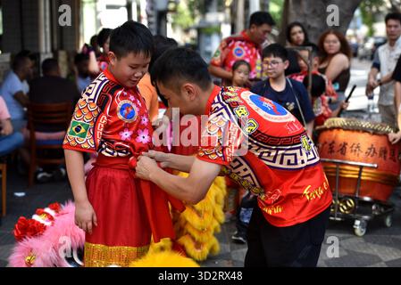 Devant la salle de l'Association générale du Brésil Guangdong à São Paulo, Brésil, le 25 octobre 2025. Zhu Zhiguo (à droite) est sur le point de fixer la ceinture pour un jeune stagiaire. São Paulo, Brésil.26 octobre 2025. L'événement annuel double neuvième Festival du respect des personnes âgées pour les compatriotes du Guangdong s'est tenu à São Paulo, au Brésil, le 26 octobre 2025. Les jeunes membres de la troupe de danse du Dragon et du Lion de l'Association du Guangdong du Brésil ont fait leurs débuts officiels lors de la soirée avec un succès remarquable. En juin de cette année, l'Association brésilienne Guangdong a rétabli le premier Dr. Banque D'Images