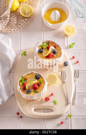 Cheesecake New-yorkais maison aromatisé à la vanille et au citron. Cheesecake au citron avec fruits à baies. Banque D'Images