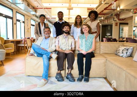 Équipe d'affaires diversifiée souriant au bureau de coworking moderne Banque D'Images