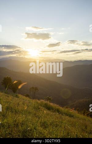 Soleil doré paisible sur de beaux paysages de montagne au lever du soleil. Vue imprenable de la colline herbeuse montrant la nature sereine pour l'aventure en plein air Banque D'Images