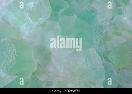 Fond naturel abstrait de pierres de fluorite brutes dans un vert doux. Texture minérale cristalline de menthe, ressource de fond macro en gros plan, espace de copie. Banque D'Images