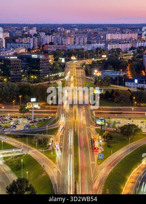 Bratislava, Slovaquie - 18 octobre 2025 : vue aérienne d'une autoroute très fréquentée de Bratislava au crépuscule, avec des traînées de lumière de véhicules, entourée par bui urbain Banque D'Images