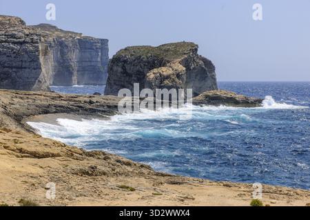 Surf de mer rugueux pendant la tempête d'automne de hautes falaises accidentées brûlent sur la côte de plage sur la mer Méditerranée de l'île de Gozo, Gozo, Malte Banque D'Images