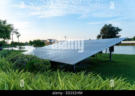 Un grand panneaux solaires sont inclinés sur une parcelle d'herbe verte. Concept d'énergie propre, de durabilité et de technologie d'énergie renouvelable. Banque D'Images