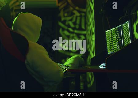 Pirate utilisant un logiciel malveillant informatique et piratant l'interface numérique verte de code binaire Banque D'Images