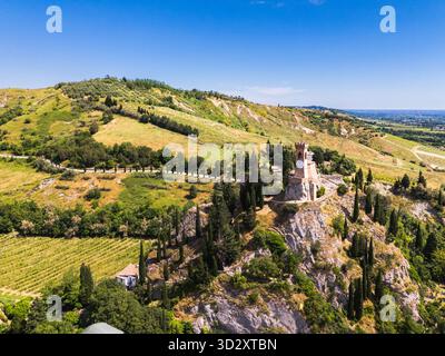 Vue aérienne de la tour de l'horloge médiévale et des vignobles environnants sur une colline rocheuse à Brisighella, Emilie-Romagne, Italie Banque D'Images