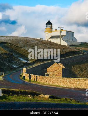 Les gens marchent sur la route du phare de Stoer Head à Sutherland, en Écosse, un jour avec un mélange de soleil et de nuages Banque D'Images