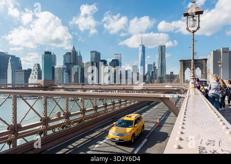 New York City, NY, États-Unis. 17 octobre 2014 : un taxi jaune survole l'emblématique pont de Brooklyn à New York. Banque D'Images