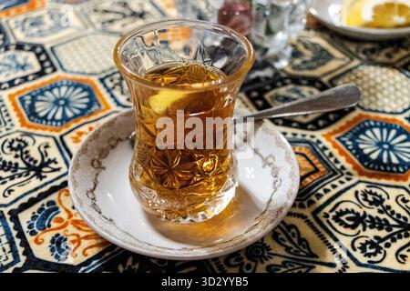 Bakou, Azerbaïdjan. Thé noir azerbaïdjanais dans un verre à thé armudu. Atmosphère de Bakou et traditions orientales. Cuisine orientale. Atmosphère chaleureuse dans le cauca Banque D'Images