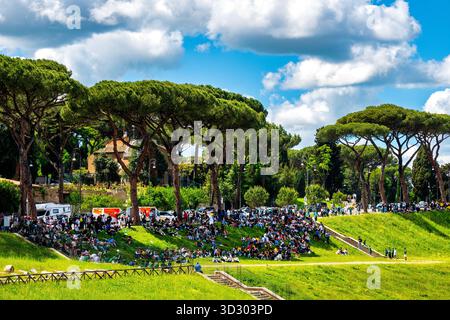 Les gens se rassemblent sous les arbres du Circo Massimo à Rome, en Italie, pour échapper au soleil de midi. Banque D'Images