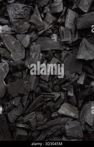 Fond abstrait de morceaux de charbon de bois brut et noir, plein cadre. Banque D'Images