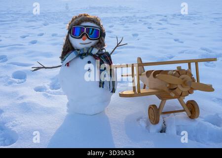 Bonhomme de neige dans la nature enneigée. Bonhomme de neige sur le champ d'hiver extérieur. Bonhomme de neige d'hiver pour la conception du nouvel an. Bonhomme de neige avec écharpe et gants. Bonhomme de neige avec espace de copie Banque D'Images