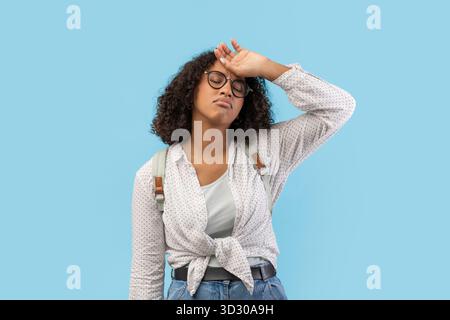 Épuisée jeune étudiante noire se sentant dépassée lors de la préparation de l'examen Banque D'Images