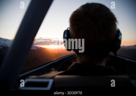 Pilote volant dans le coucher du soleil près de Eyjafjallajokull, Islande. Banque D'Images