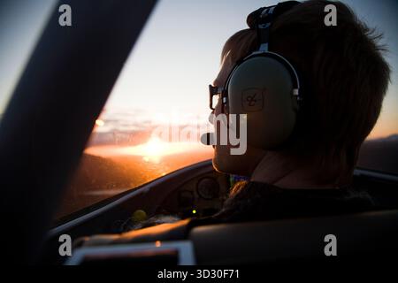 Pilote volant dans le coucher du soleil, Islande. Banque D'Images