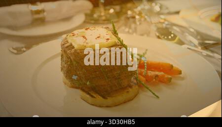 Filet mignon Steak assis dans le filet à griller sur la table à manger, avec du beurre et des carottes glacées Banque D'Images