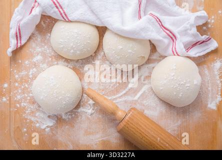Morceaux de pâte à pain crue sur la table de cuisine en bois, pain de cuisson ou pizza Banque D'Images