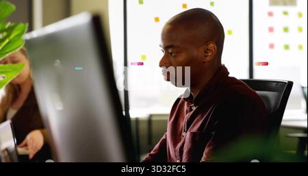 Revoir collègue avec le moniteur de visualisation de chemise Bordeaux dans le bureau, avec des notes adhésives, espace de copie Banque D'Images