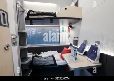 Allemagne. 02 septembre 2025. Vue dans un compartiment de couchage du Nightjet, le train de nuit des chemins de fer fédéraux autrichiens (ÖBB). Le compartiment comprend deux canapés, une table pliante, des étagères, des lampes de lecture et du matériel d'urgence. Sur la table se trouvent des bouteilles d’eau, des verres et des packs de bienvenue portant le logo ÖBB Nightjet. Le train circule sur la ligne Hambourg-Vienne. Crédit : Christian Charisius/dpa/Alamy Live News Banque D'Images