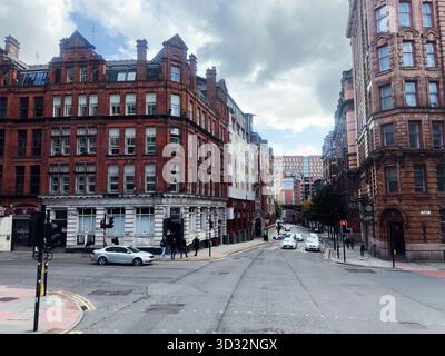 Manchester, Royaume-Uni - 29 septembre 2025 : rue animée de Manchester Whitworth avec architecture en briques rouges, piétons et circulation légère. Banque D'Images