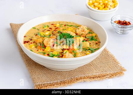 Soupe chaude et copieuse de crevettes et de chaudrée de maïs servie dans un bol Banque D'Images