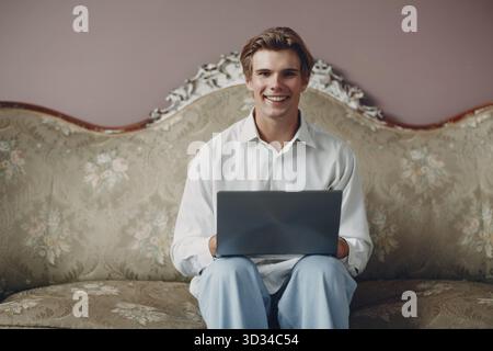 Portrait jeune homme européen assis avec un ordinateur portable lors d'un appel vidéo web conférence. Concept de travail à domicile Banque D'Images