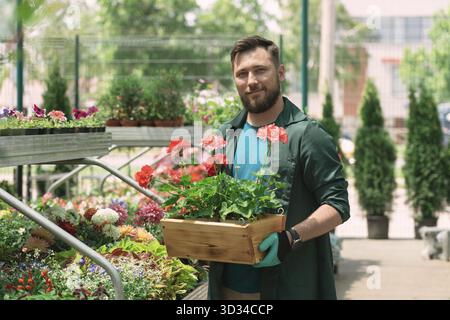 Fleuriste arrangeant des pots de fleurs dans le magasin de jardin Banque D'Images