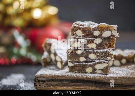 Morceaux de gâteau de fête de Noël à bord de la pile avec amandes Banque D'Images