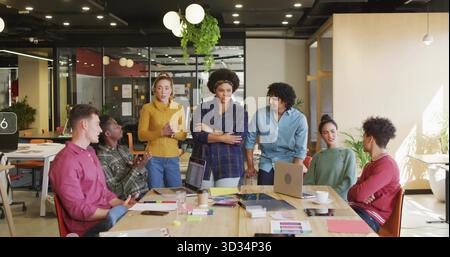 Discuter des tâches du projet équipe de collègues collaborant autour d'une table de conférence au bureau avec des ordinateurs portables Banque D'Images