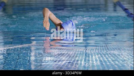 Nageur de compétition de natation portant un bonnet de bain bleu et des lunettes dans l'eau claire de la piscine, avec des cordes de voie Banque D'Images