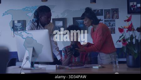 Examen de trois professionnels examinant l'affichage de l'appareil photo reflex numérique au bureau, avec une carte du monde graphique Banque D'Images