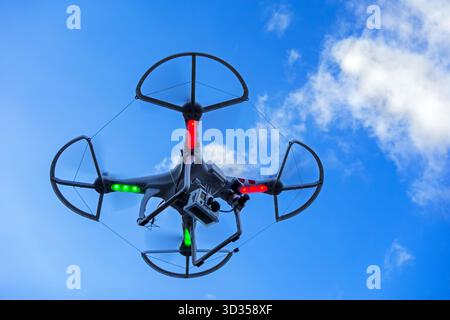 Drone quadcopter miniature / véhicule aérien télécommandé sans pilote / UAV équipé d'une caméra pour la photographie aérienne en vol contre ciel bleu Banque D'Images