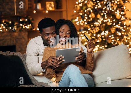 Heureux couple aime acheter en ligne ensemble dans le cadre confortable de vacances Banque D'Images