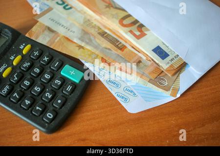 Cinquante billets en euros avec Calculatrice sur une enveloppe Banque D'Images
